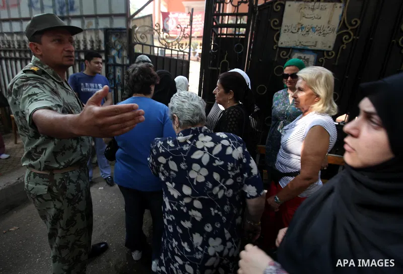 Egyptian women wait outside a polling station in Cairo to cast their votes on June 16, 2012 in a divisive presidential runoff pitting ousted strongman Hosni Mubarak's last premier Ahmed Shafiq against Muslim Brotherhood...