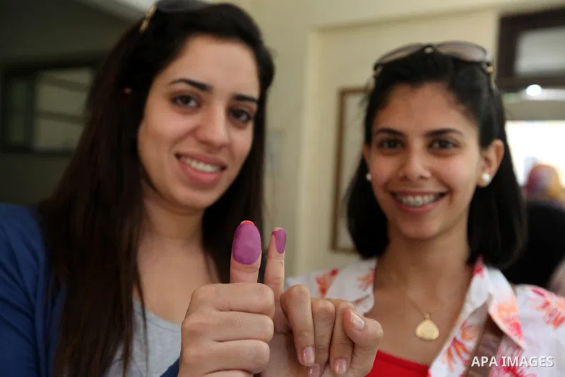 Egyptian women show their ink-stained finger after casting her vote at a polling station in Cairo on June 16, 2012 in a divisive presidential runoff pitting ousted strongman Hosni Mubarak's last premier Ahmed Shafiq agai...