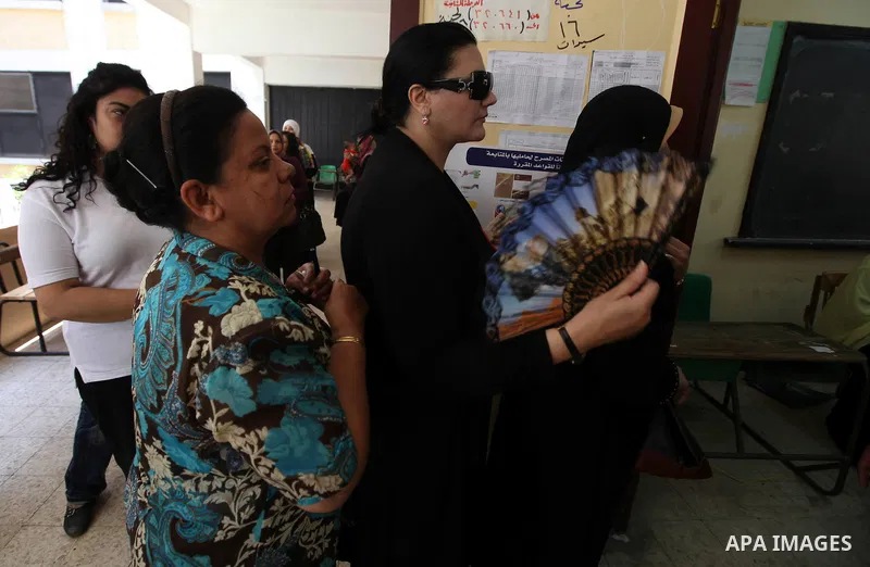 Egyptians queue outside a polling station in Cairo on June 16, 2012 to vote in a divisive presidential runoff pitting ousted strongman Hosni Mubarak's last premier Ahmed Shafiq against Muslim Brotherhood candidate Mohamm...