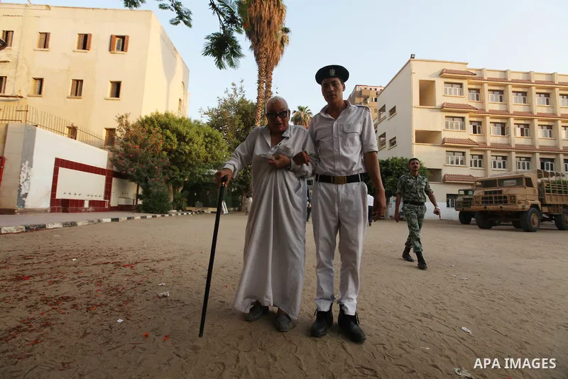An Egyptian elderly is helped by soldiers upon his arrival at a polling station to vote on the first day of the second round of the historical presidential election in the city of Zagazig, 90 kms north of Cairo in the ea...