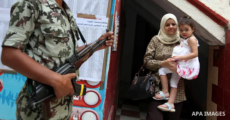 An Egyptian woman exits a polling station in Cairo after cast their votes on June 17, 2012 in a divisive presidential runoff pitting ousted strongman Hosni Mubarak's last premier Ahmed Shafiq against Muslim Brotherhood c...
