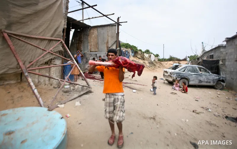 A Palestinian man carries the meet of a slaughtered horse in a poor neighborhood in the central Gaza Strip on 15 June 2012. The people of the poor neighborhood in the center of Gaza strip slaughter horses every twenty da...