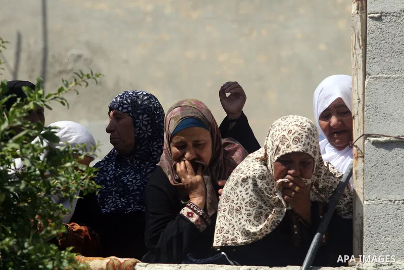 Relatives of Naim al-Najjar, look at his funeral in the West Bank village of Idhna, near Hebron, Sunday, June 17, 2012. An Israeli tow truck driver shot dead two Palestinians and wounded one Sunday during what Israeli po...