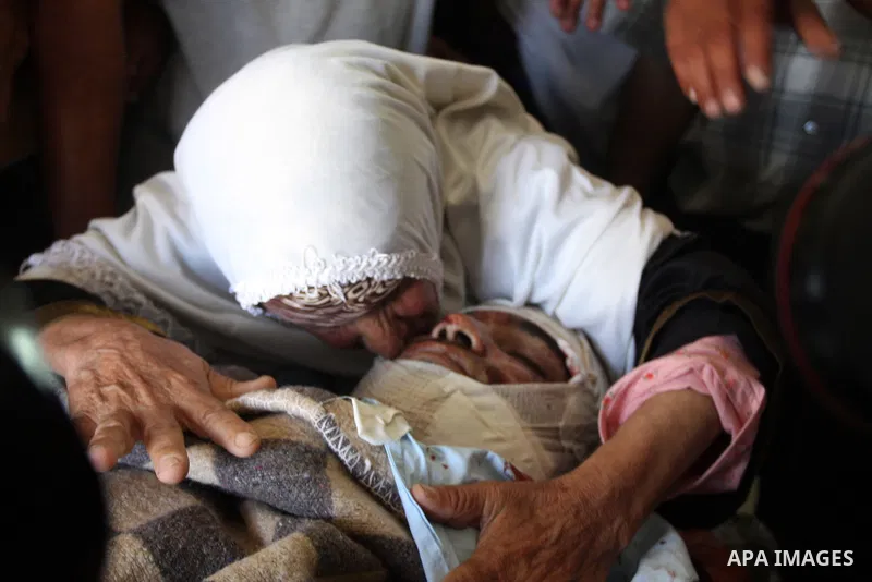 A Palestinian woman kisses the dead body of Naim al-Najar during a funeral in the West Bank village of Idhna, near Hebron, Sunday, June 17, 2012. An Israeli tow truck driver shot dead two Palestinians and wounded one Sun...
