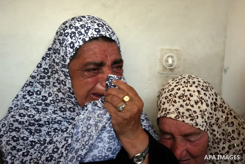 The mother (R) of Naim Najar cries during his funeral in the West Bank village of Idhna, near Hebron, Sunday, June 17, 2012. An Israeli tow truck driver shot dead two Palestinians and wounded one Sunday during what Israe...