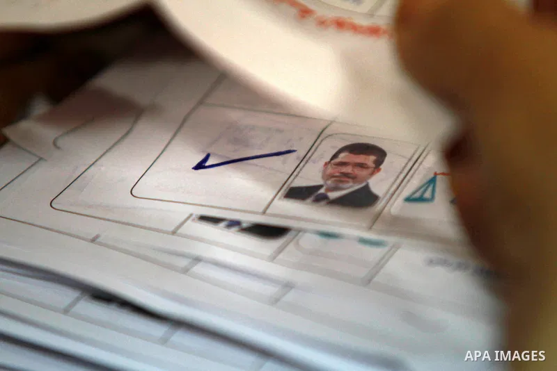 An electoral worker counts ballots voting for Muslim Brotherhood's presidential candidate Mohamed Morsy, after polls closed in Cairo June 17, 2012. Egyptians began an anxious wait for their first freely elected president...