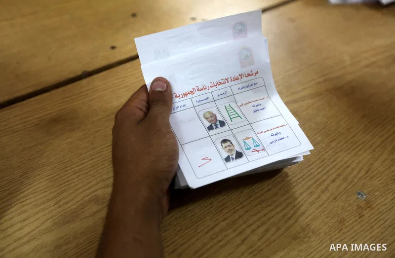 An electoral worker counts ballots voting for Muslim Brotherhood's presidential candidate Mohamed Morsy, after polls closed in Cairo June 17, 2012. Egyptians began an anxious wait for their first freely elected president...