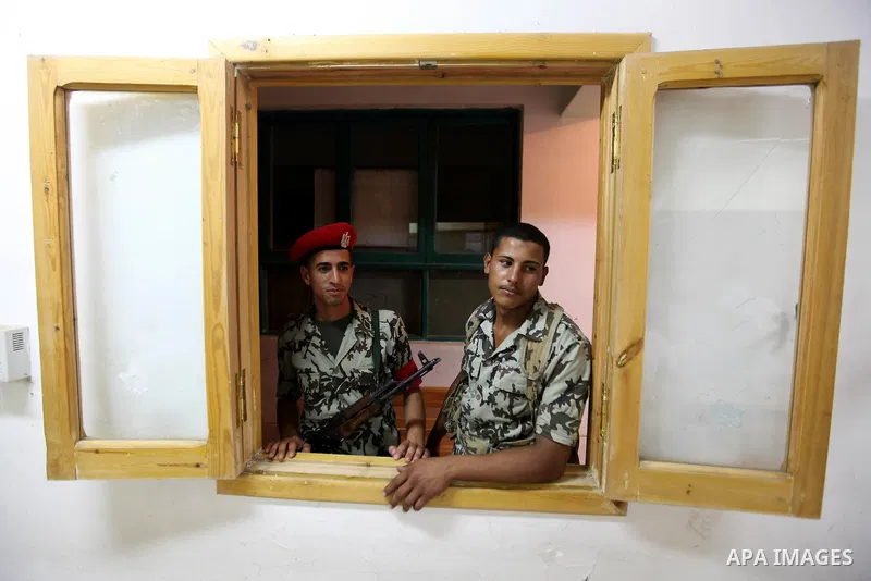 Egyptian soldiers stand alert as election officials count ballots at a polling center on the second day of the presidential runoff, in Cairo, Egypt, Sunday, June 17, 2012. Egyptians voted for a second day Sunday in a pre...