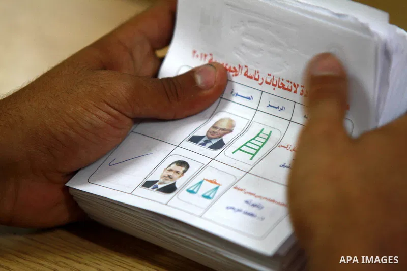 An electoral worker counts ballots voting for Muslim Brotherhood's presidential candidate Mohamed Morsy, after polls closed in Cairo June 17, 2012. Egyptians began an anxious wait for their first freely elected president...