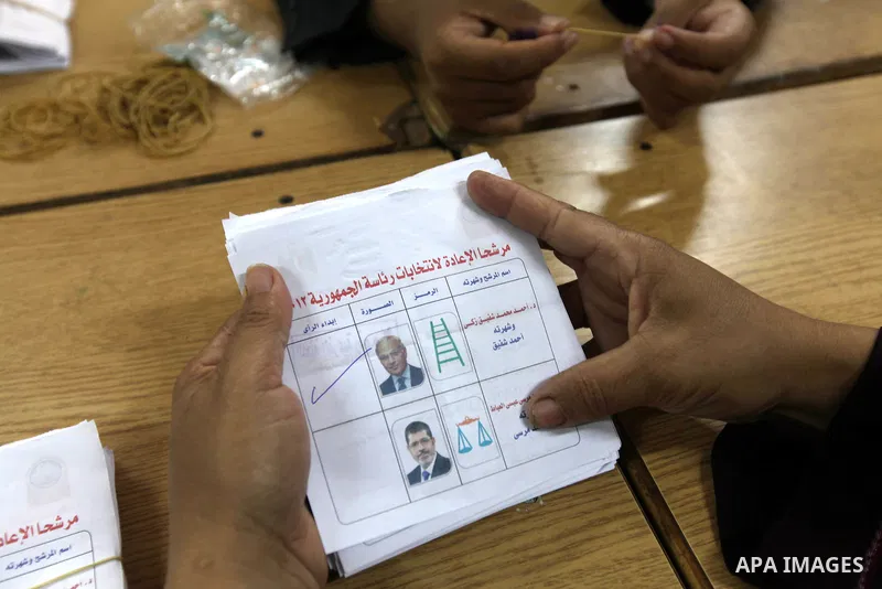 An electoral worker counts ballots voting for former prime minister and presidential candidate Ahmed Shafik, after polls closed in Cairo June 17, 2012. Egyptians began an anxious wait for their first freely elected presi...