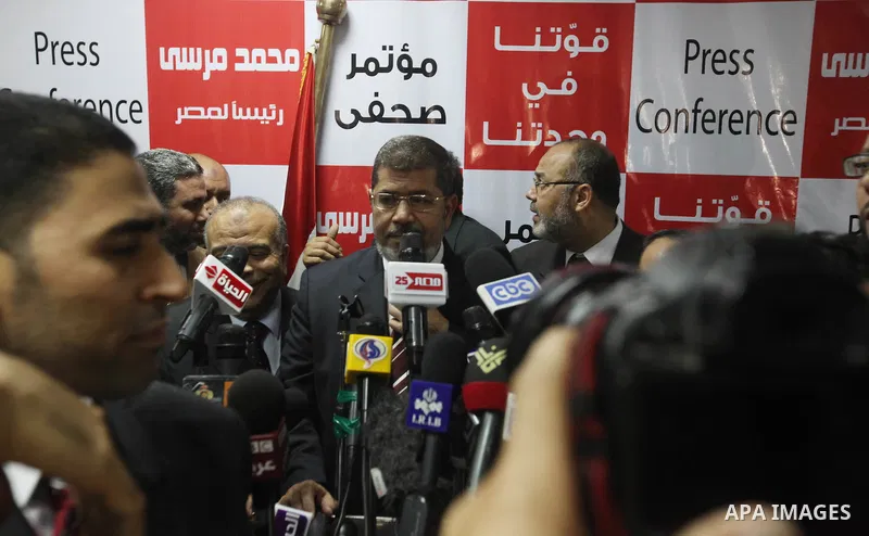 Egypt's Muslim Brotherhood candidate Mohammed Mursi waves amongst his supporters after the announcement of presidential election results at the electoral headquarters in Cairo on June 18, 2012. The campaign of Egyptian p...