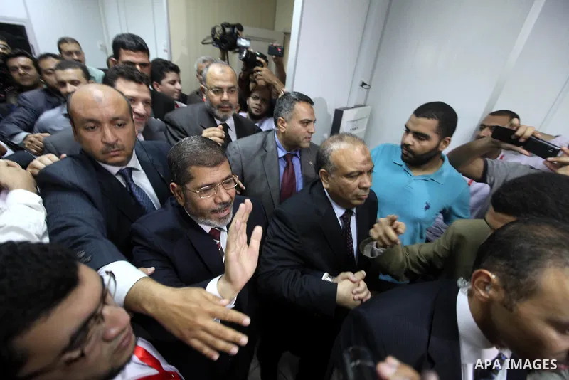 Egypt's Muslim Brotherhood candidate Mohammed Mursi waves amongst his supporters after the announcement of presidential election results at the electoral headquarters in Cairo on June 18, 2012. The campaign of Egyptian p...