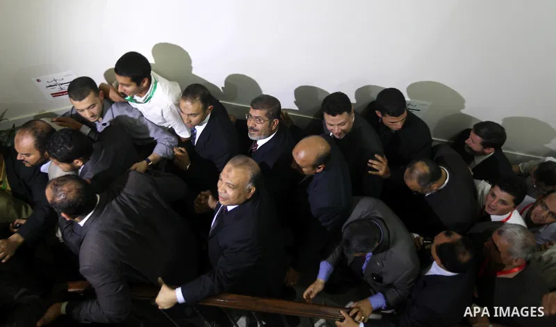 Egypt's Muslim Brotherhood candidate Mohammed Mursi waves amongst his supporters after the announcement of presidential election results at the electoral headquarters in Cairo on June 18, 2012. The campaign of Egyptian p...