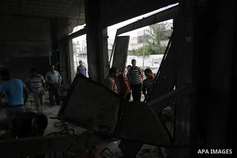 Palestinians survey a destroyed metal workshop after an Israeli air strike in Rafah, in the southern Gaza Strip June 18, 2012. Overnight on Sunday, Israeli aircraft carried out a series of strikes in the Gaza Strip in re...