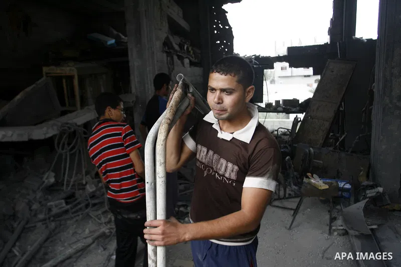 Palestinians survey a destroyed metal workshop after an Israeli air strike in Rafah, in the southern Gaza Strip June 18, 2012. Overnight on Sunday, Israeli aircraft carried out a series of strikes in the Gaza Strip in re...
