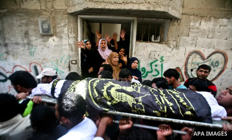Palestinian mourners carry the body of one of the two Palestinians who were killed in an Israeli air strike on north Gaza during their funeral on June 18, 2012. Witnesses identified the two men as members of the radical...