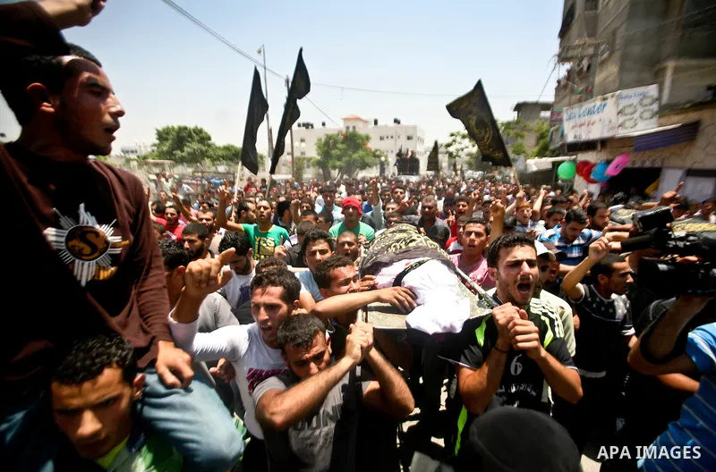 Palestinian mourners carry the body of one of the two Palestinians who were killed in an Israeli air strike on north Gaza during their funeral on June 18, 2012. Witnesses identified the two men as members of the radical...