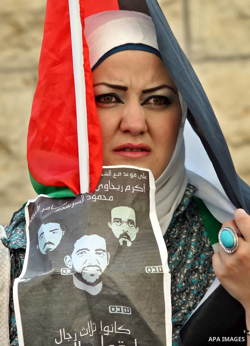 Palestinian protestors hold pictures of Palestinian prisoner Mahmoud Al-Sarsak, who is still refusing food for 96 days after a deal was made to end a mass prisoner hunger strike, during a demonstration in support him, in...
