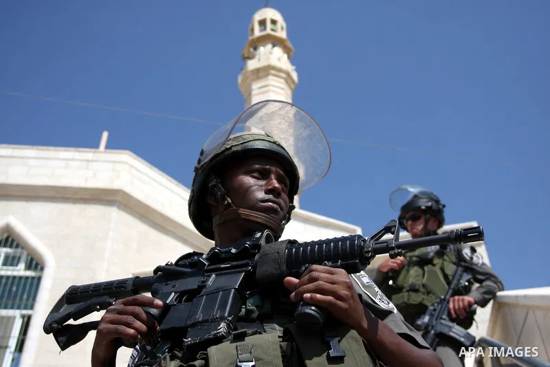 Israeli border police officers stand outside a damaged mosque in West Bank village of Jaba near Ramallah June 19, 2012. The mosque in the occupied West Bank was vandalised and set on fire early on Tuesday, in an attack P...