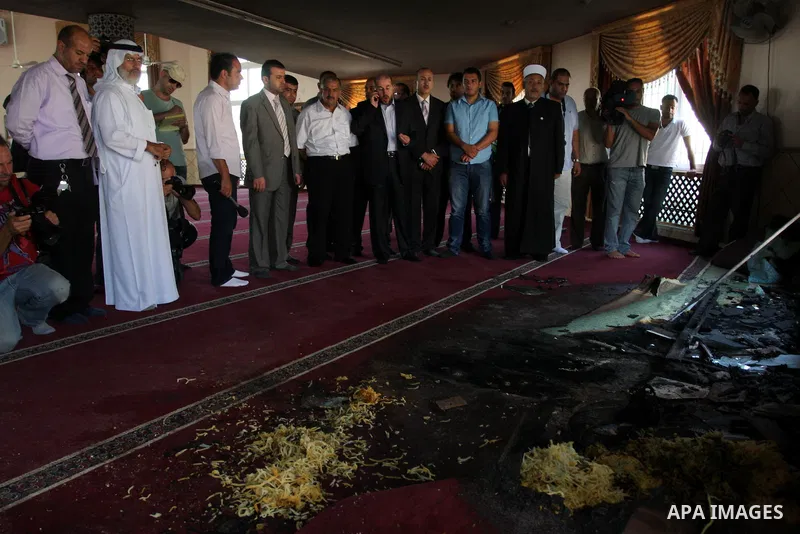 Palestinians men stand inside a damaged mosque in West Bank village of Jaba near Ramallah June 19, 2012. The mosque in the occupied West Bank was vandalised and set on fire early on Tuesday, in an attack Palestinians bla...
