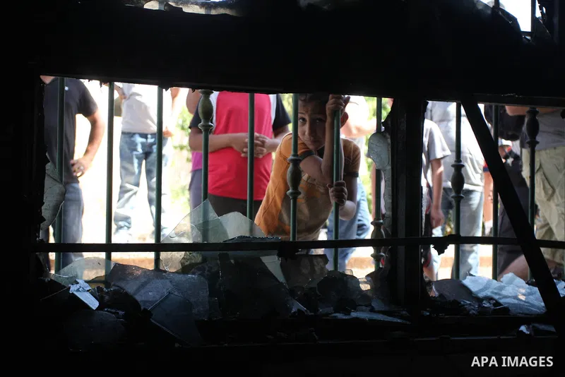 Palestinians look into a damaged mosque in West Bank village of Jaba near Ramallah June 19, 2012. The mosque in the occupied West Bank was vandalised and set on fire early on Tuesday, in an attack Palestinians blamed on...