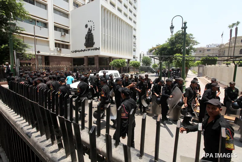 Egyptian riot police stand outside the parliament as protesters gather in Cairo, on June 19, 2012, after the Supreme Council of the Armed Forces (SCAF) issued a constitutional declaration on June 17, claiming legislative...