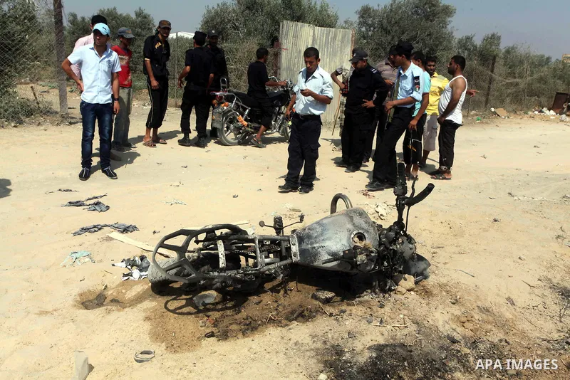Hamas policemen stands near a motorcycle that was hit in an Israeli air strike in Dir al-Balah in the central Gaza Strip June 19, 2012. An Israeli army statement said the Israeli air force targeted Palestinian militants...