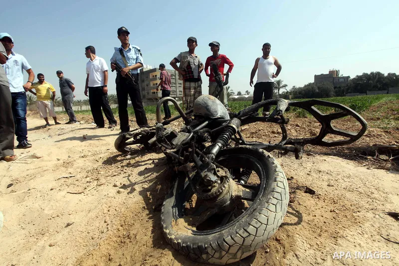 A Hamas policeman looks at a motorcycle that was hit in an Israeli air strike in Dir al-Balah in the central Gaza Strip June 19, 2012. An Israeli army statement said the Israeli air force targeted Palestinian militants i...