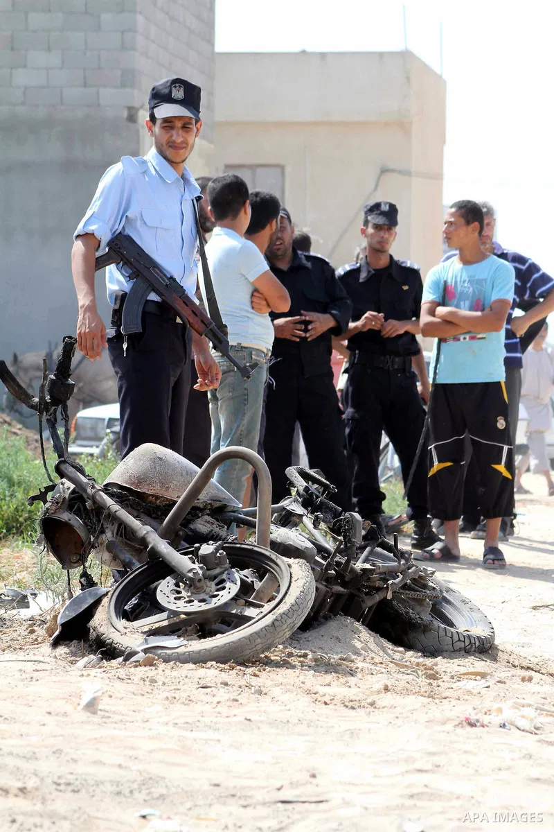 A Hamas policeman stands near a motorcycle that was hit in an Israeli air strike in Dir al-Balah in the central Gaza Strip June 19, 2012. An Israeli army statement said the Israeli air force targeted Palestinian militant...