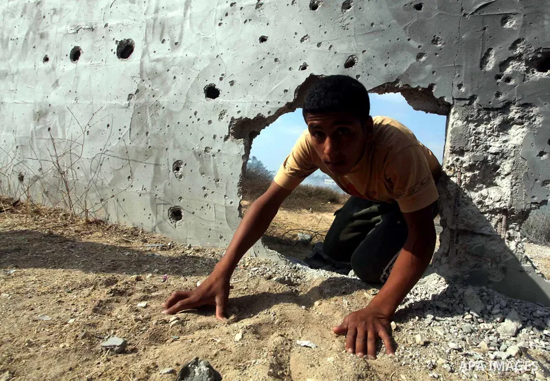 A Palestinian child inspects the place that was under an Israeli air strike in Dir al-Balah in the central Gaza Strip June 19, 2012. An Israeli army statement said the Israeli air force targeted Palestinian militants in...