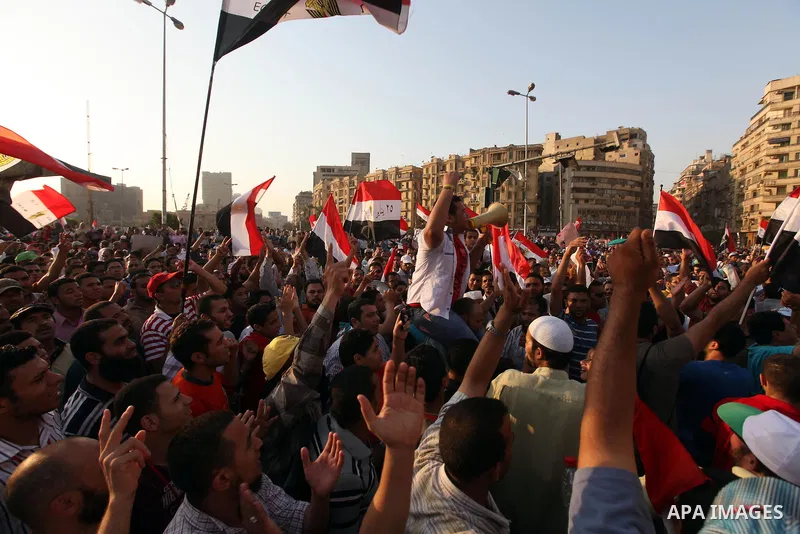 Egyptian supporters of Muslim Brotherhood presidential candidate Mohammed Mursi wave their national flag as they gather in Cairo's Tahrir Square on June 19, 2012 to protest against the ruling military's bid to grab new p...