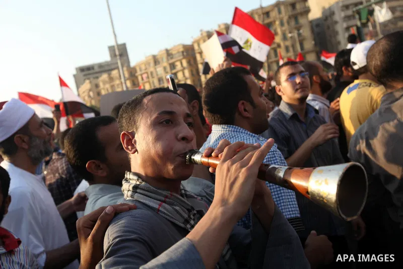 Egyptian supporters of Muslim Brotherhood presidential candidate Mohammed Mursi wave their national flag as they gather in Cairo's Tahrir Square on June 19, 2012 to protest against the ruling military's bid to grab new p...