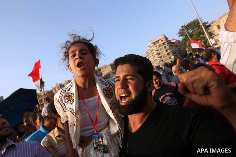 Egyptian supporters of Muslim Brotherhood presidential candidate Mohammed Mursi wave their national flag as they gather in Cairo's Tahrir Square on June 19, 2012 to protest against the ruling military's bid to grab new p...