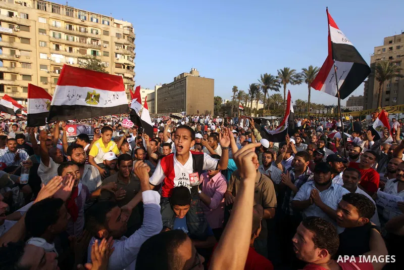 Egyptian supporters of Muslim Brotherhood presidential candidate Mohammed Mursi wave their national flag as they gather in Cairo's Tahrir Square on June 19, 2012 to protest against the ruling military's bid to grab new p...