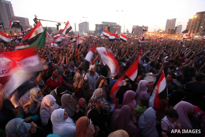 Egyptian supporters of Muslim Brotherhood presidential candidate Mohammed Mursi wave their national flag as they gather in Cairo's Tahrir Square on June 19, 2012 to protest against the ruling military's bid to grab new p...