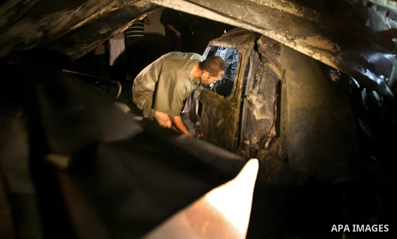 A Palestinian inspects a destroyed car after it was hit in an Israeli air strike in Al Zaiton area in the east of Gaza city on, 20 June 2012. Photo by Ali Jadallah