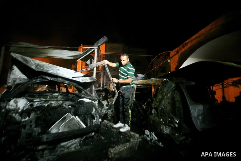 A Palestinian inspects a destroyed car after it was hit in an Israeli air strike in Al Zaiton area in the east of Gaza city on, 20 June 2012. Photo by Ali Jadallah