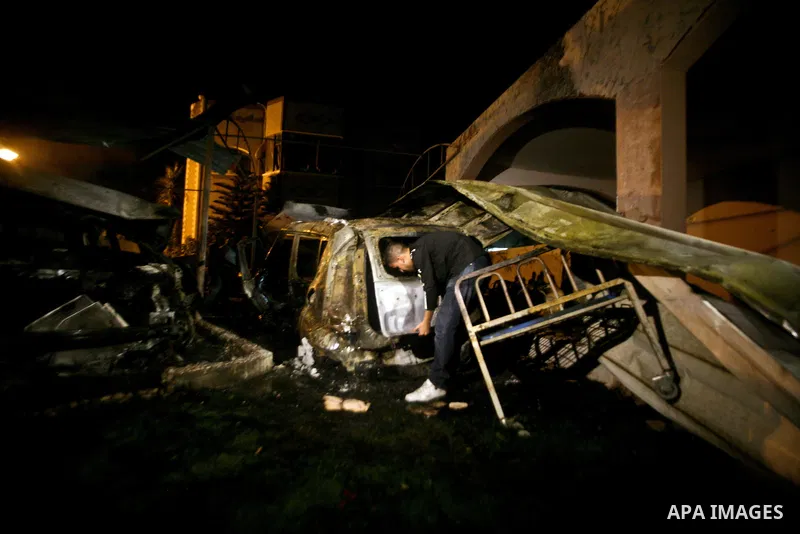 A Palestinian inspects a destroyed car after it was hit in an Israeli air strike in Al Zaiton area in the east of Gaza city on, 20 June 2012. Photo by Ali Jadallah