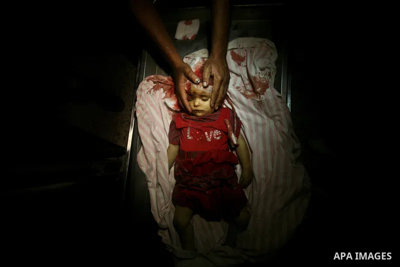 A Palestinian man looks at the body of two-year-old girl, Hadeel al-Hadad, at a hospital in Gaza City June 19, 2012. Israel killed two Palestinians in air strikes and Hamas fired its first cross-border rocket barrages in...