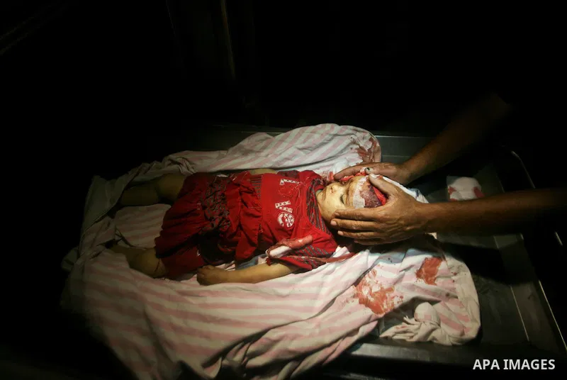 A Palestinian man looks at the body of two-year-old girl, Hadeel al-Hadad, at a hospital in Gaza City June 19, 2012. Israel killed two Palestinians in air strikes and Hamas fired its first cross-border rocket barrages in...