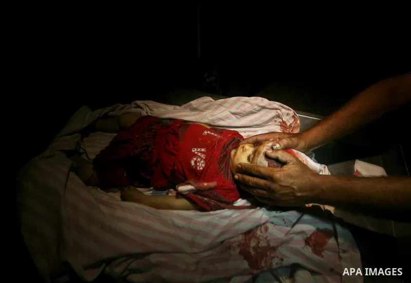 A Palestinian man looks at the body of two-year-old girl, Hadeel al-Hadad, at a hospital in Gaza City June 19, 2012. Israel killed two Palestinians in air strikes and Hamas fired its first cross-border rocket barrages in...