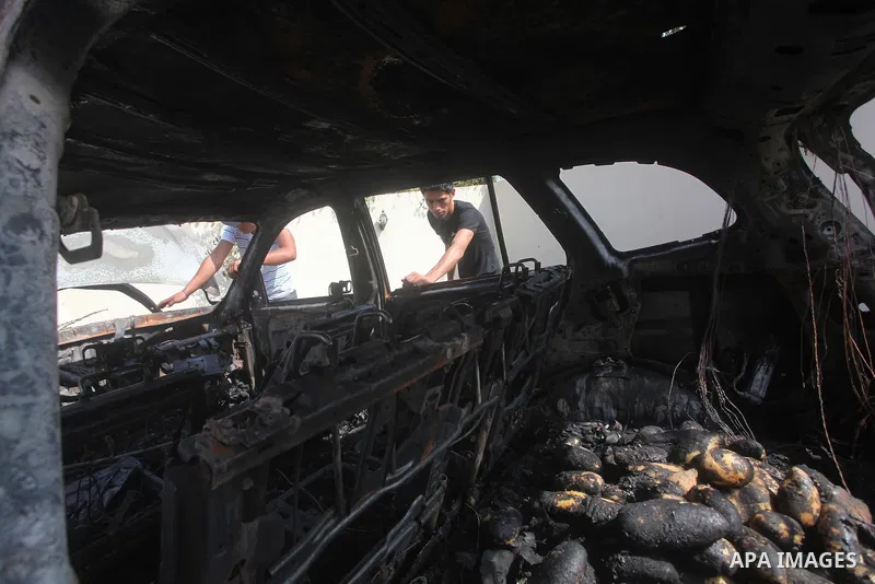Palestinians are seen through a burnt cars of the potato outside a house after an Israeli air strike in Dir al-Balah in the central in the Gaza Strip June 20, 2012. The Israeli military said it had struck militant sites...
