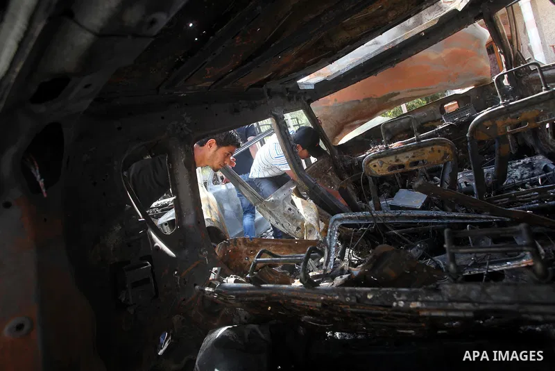 Palestinians are seen through a burnt cars of the potato outside a house after an Israeli air strike in Dir al-Balah in the central in the Gaza Strip June 20, 2012. The Israeli military said it had struck militant sites...