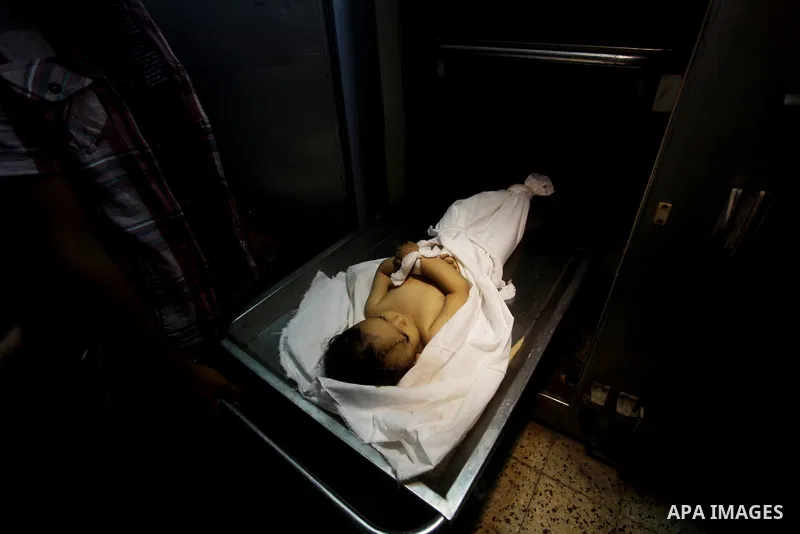 A Palestinian looks at the body of two-year-old girl, Hadeel al-Hadad, at the morgue in the al-Shifa hospital in Gaza City on June 20, 2012. There was no let-up in rocket fire from Gaza with at least 10 hitting the Jewis...