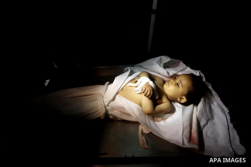 A Palestinian looks at the body of two-year-old girl, Hadeel al-Hadad, at the morgue in the al-Shifa hospital in Gaza City on June 20, 2012. There was no let-up in rocket fire from Gaza with at least 10 hitting the Jewis...