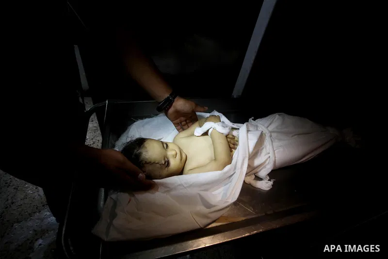 A Palestinian looks at the body of two-year-old girl, Hadeel al-Hadad, at the morgue in the al-Shifa hospital in Gaza City on June 20, 2012. There was no let-up in rocket fire from Gaza with at least 10 hitting the Jewis...