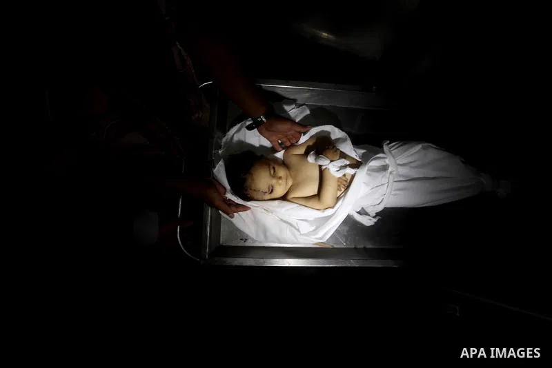 A Palestinian looks at the body of two-year-old girl, Hadeel al-Hadad, at the morgue in the al-Shifa hospital in Gaza City on June 20, 2012. There was no let-up in rocket fire from Gaza with at least 10 hitting the Jewis...