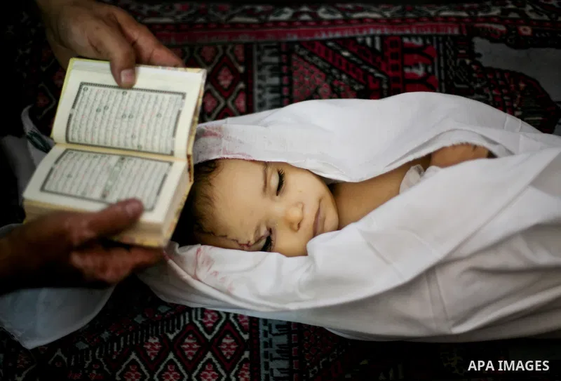 Palestinian mourners pray over the body of Hadeel al-Hadad during her funeral in Gaza City on 20 June 2012. Hadeel was killed June 19 when Palestinian militants launched a rocket from Gaza City, which failed to reach its...