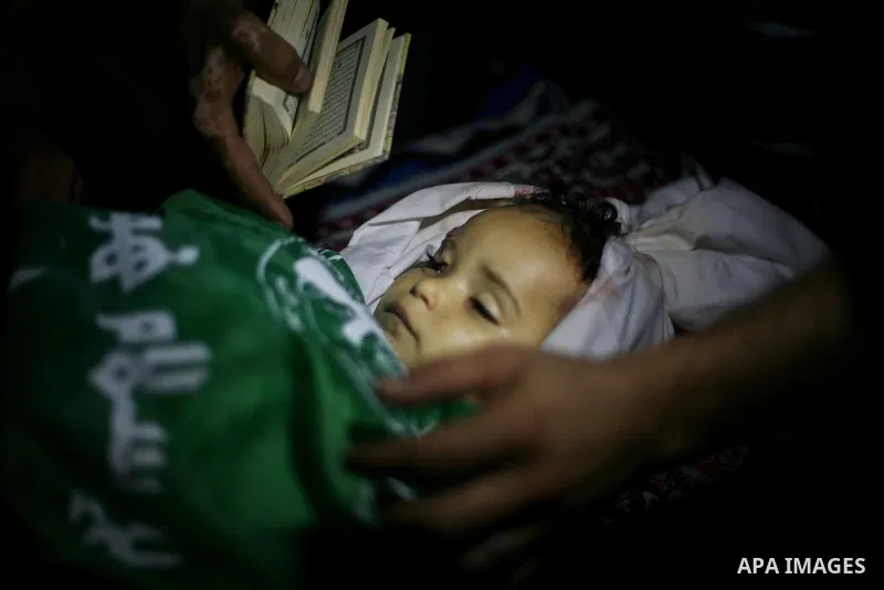 Palestinian mourners pray over the body of Hadeel al-Hadad during her funeral in Gaza City on 20 June 2012. Hadeel was killed June 19 when Palestinian militants launched a rocket from Gaza City, which failed to reach its...