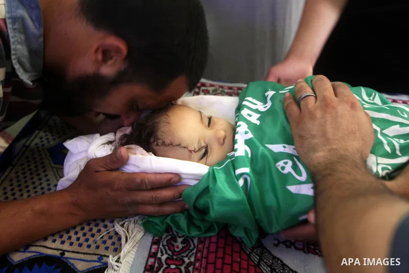 A Palestinian relative kisses the body of two-year-old Hadeel al Hadad, during her funeral in Gaza City, Wednesday, June 20, 2012. Gaza health official Adham Abu Salmia said an explosion in a house killed al-Hadad and in...